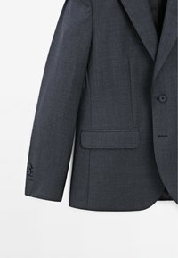 Dunkelgrauer Blazer aus strukturiertem Stoff. Mit Reverskragen, einzelnem Knopfverschluss und seitlicher Tasche. Schmal geschnitten mit eleganter Design.