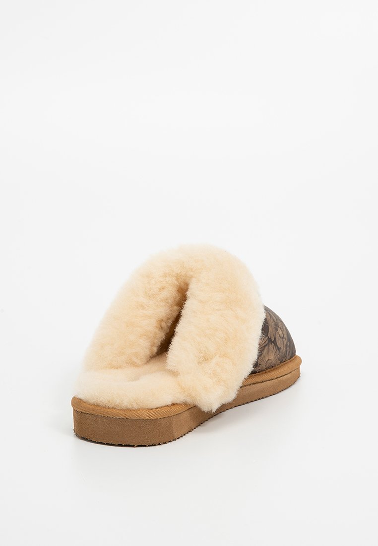 Bruine faux fur slippers met een zachte beige voering, open achterkant en een gestructureerde rubberen zool voor grip. Ontworpen voor comfort en warmte.
