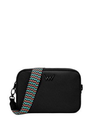 Ribbed orange dress with three-quarter sleeves; black bag with a zigzag strap featuring red and green accents, held at an angle.