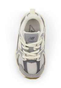 Harmaa- ja valkoinen juoksukenkä, jossa on verkkomainen päälliosa, pehmustettu kieli ja teksturoidut yksityiskohdat. Kengässä on nauhat ja kumiulkopohja.