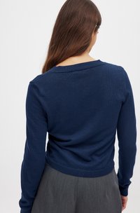Marineblauwe langetermijn pullover trui met een geribbelde ronde halslijn en een getailleerde taille. Gladde textuur, lichtgewicht stof.