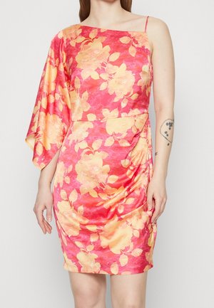Robe fleurie asymétrique rose et jaune avec une manche longue et une fine bretelle, portée par une personne avec un tatouage sur le bras droit.
