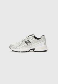 Baskets de sport pour hommes en mesh argent et blanc avec des accents noirs. Comprend une semelle rembourrée et un bout arrondi. Logo "N" sur le côté.