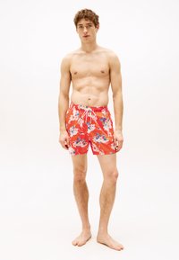 Shorts de baie roșii cu flori, având un tiv ajustabil cu șnur și un model vibrant de flori albastre și roz. Fabricate dintr-un material ușor.