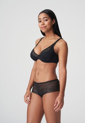 Schwarzer Spitzen-BH mit Unterwäsche und satinierter Oberfläche, kombiniert mit passenden, durchsichtigen Shorts in Boyshorts-Form mit floralem Muster. Beide Teile verfügen über verstellbare Träger.