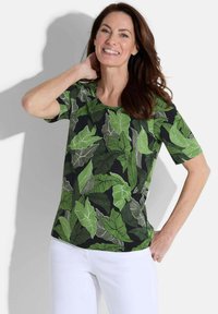 Korte mouwen shirt met een zwarte achtergrond en levendige groene bladerenpatronen. Gemaakt van lichtgewicht stof, met een ronde hals en een ontspannen pasvorm.