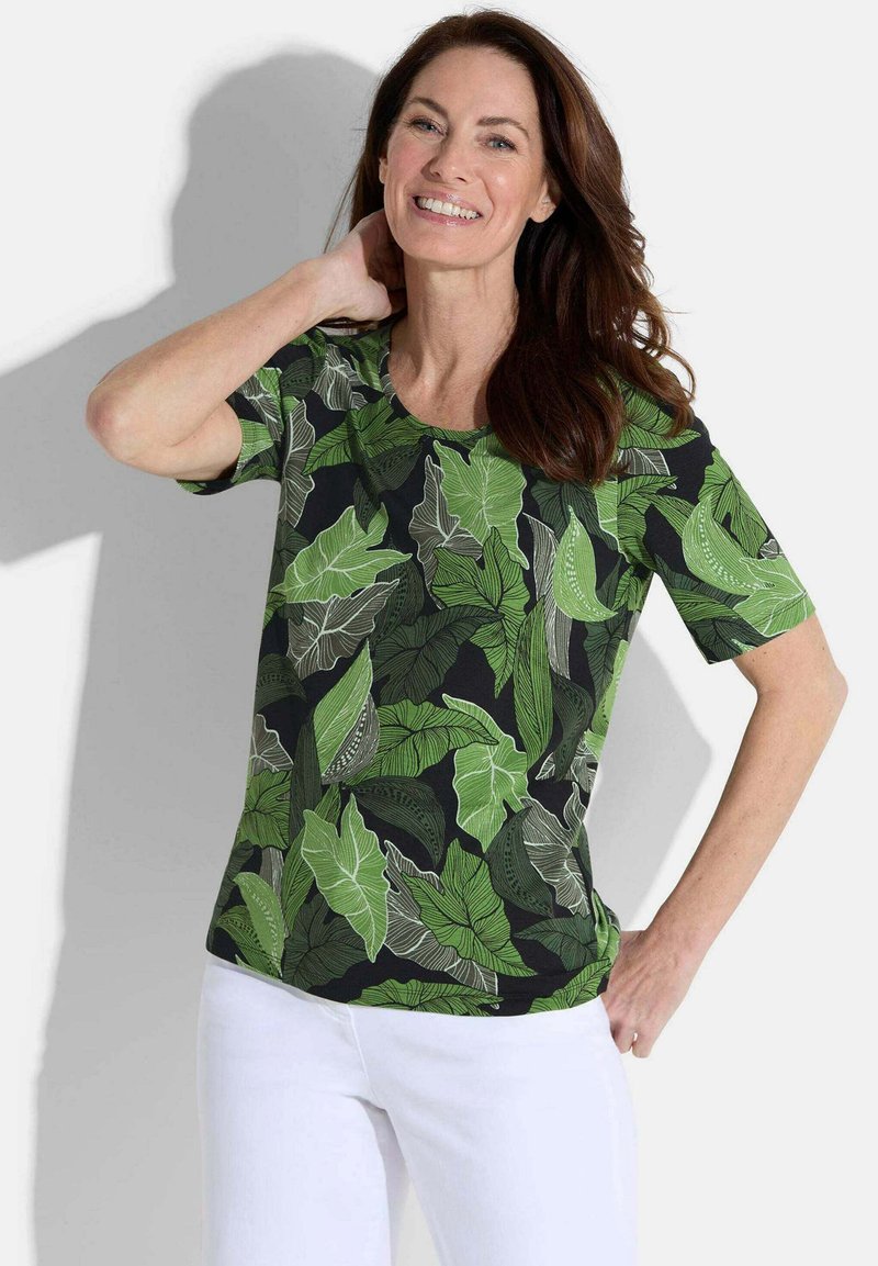 Korte mouwen shirt met een zwarte achtergrond en levendige groene bladerenpatronen. Gemaakt van lichtgewicht stof, met een ronde hals en een ontspannen pasvorm.