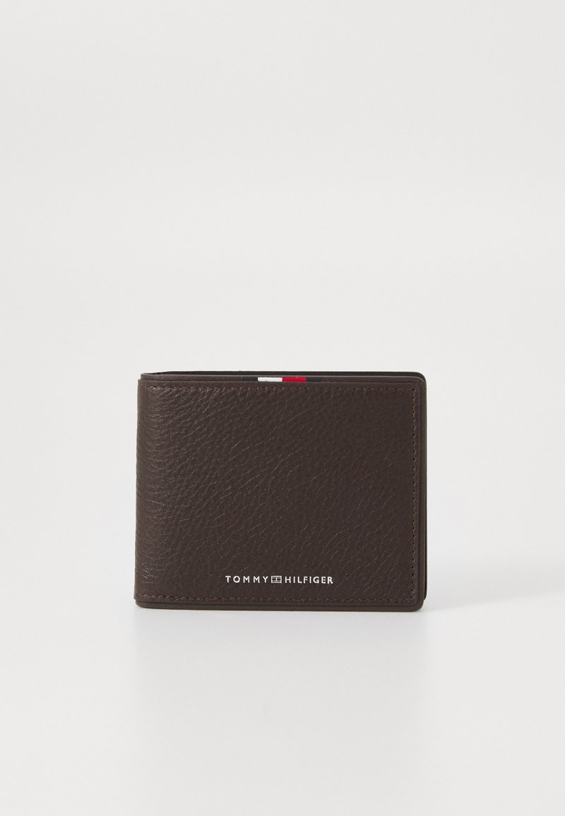 Brown leather wallet with textured finish, featuring a silver logo on the front and a red, white, and blue accent at the top edge.