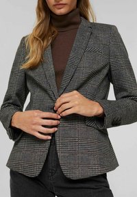 Yksivärinen ruutublazer harmaassa ja mustassa, jossa on slim fit -muotoilu, kaulusta oleva nappa ja kaksinappinen kiinnitys, yhdistettynä ruskeaan poolopaitaan.