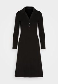 Musta ribbimäinen mekko, jossa on kaulus, pitkät hihat, nappilista ja liehukkahelma. Sileä pinta ja vartalonmyötäinen siluetti.