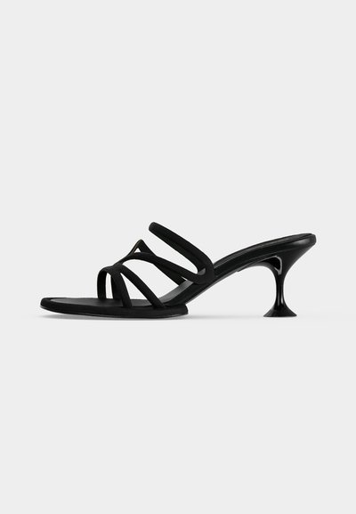 Sandale mule noire à fines lanières avec quatre brides et un talon kitten évasé sur un fond clair uni.