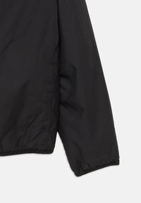 Manche de veste rembourrée noire avec une texture lisse et mate et un ourlet élastiqué. Présente une coupe décontractée et des détails matériels minimaux.