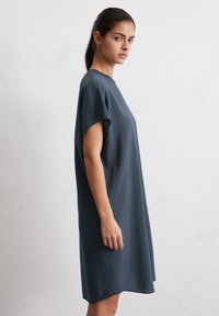 Robe gris foncé à mi-longueur avec des manches courtes, fabriquée en tissu léger et texturé ; coupe ample et encolure ronde.