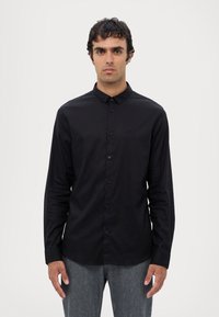 Zwarte langemouwen shirt van gladde stof, met een button-down kraag, knopen aan de voorkant en een subtiele logo op de borst.