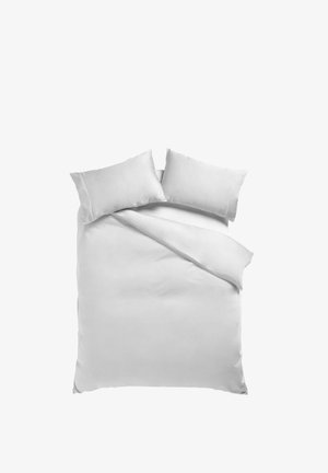 Weißes Bett mit zwei Kissen und einer leicht gefalteten Bettdecke auf einem schlichten weißen Hintergrund.