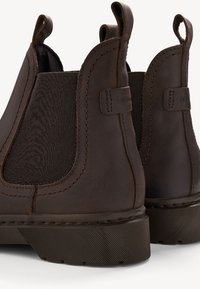 Bottines Chelsea en cuir marron avec des panneaux élastiques, des languettes de tirage et des semelles en caoutchouc texturé. Présente une couture robuste et un design élégant et minimaliste.