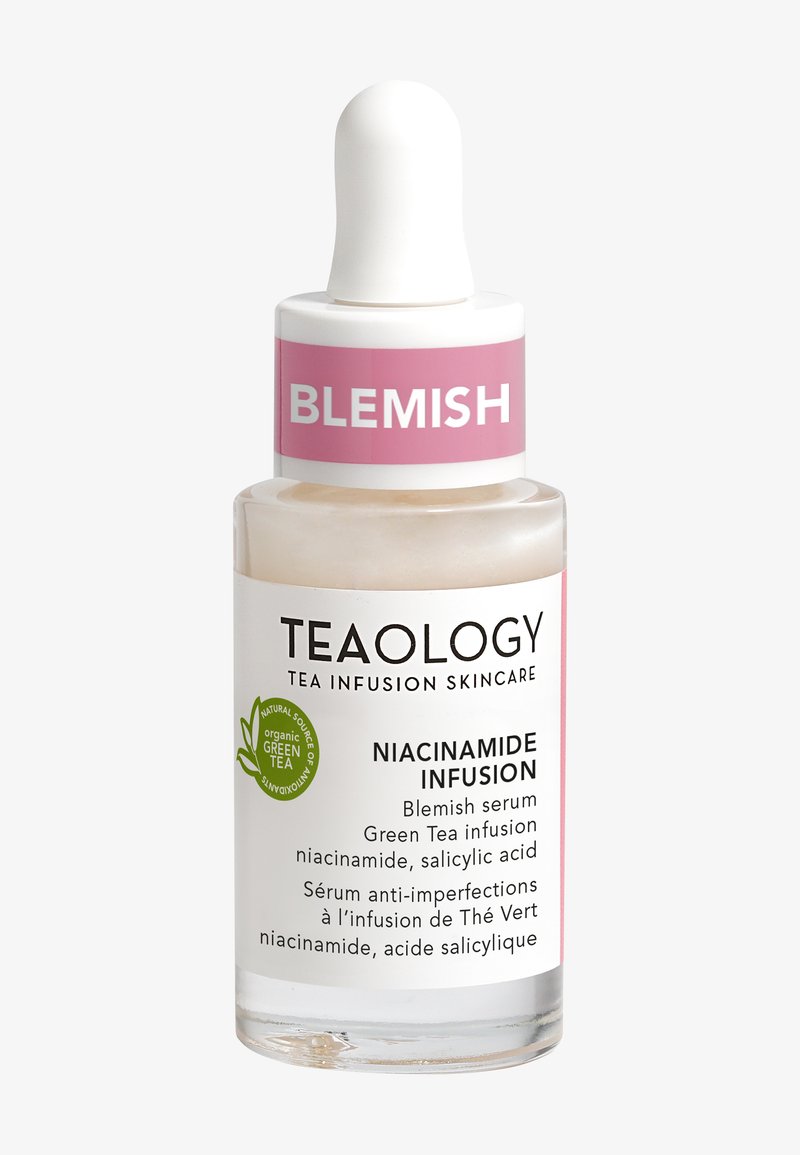 Bottiglia contagocce in vetro trasparente contenente un siero, con un tappo bianco e un'etichetta rosa che riporta la scritta "BLEMISH" e "NIACINAMIDE INFUSION."