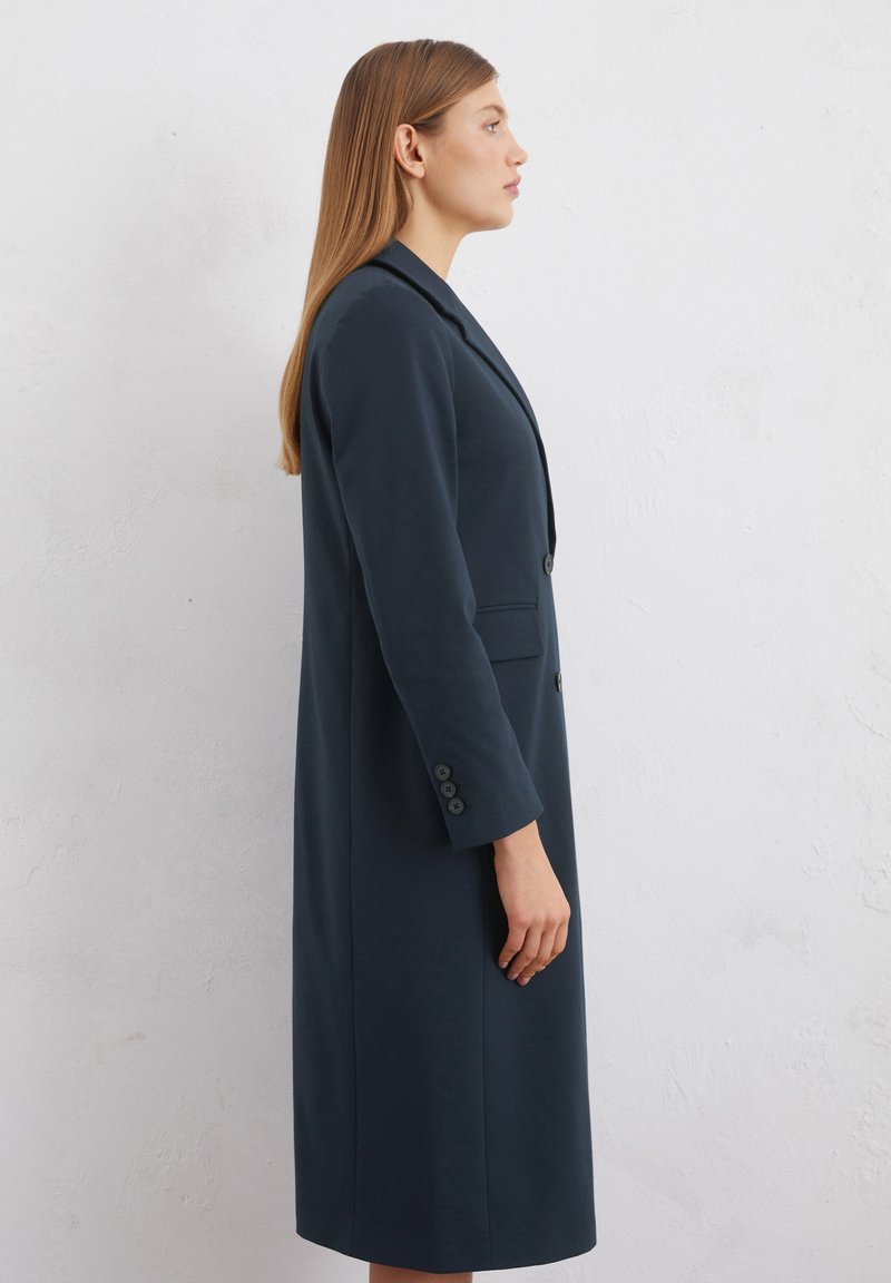 Marineblaue, lange Blazer mit schlanker Silhouette, Ein-Knopf-Verschluss, Seitentaschen und geknöpften Manschetten. Hergestellt aus glattem Stoff.