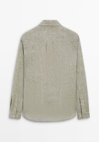 Leichtes, langärmeliges Leinenhemd in hellgrün mit texturierter Oberfläche, Ärmel mit Knopfmanschetten und Rückenteil mit Kellerfalte, flach von hinten liegend dargestellt.