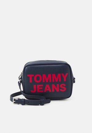 Laivastonsininen suorakaiteen muotoinen olkalaukku, jossa säädettävä hihna ja edessä punainen "TOMMY JEANS" -logo painettuna.