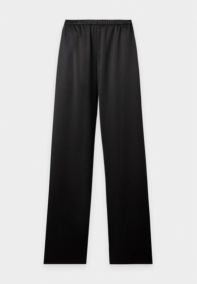 Pantalon noir ample avec ceinture élastique, coupe droite et tissu lisse, présenté sur un fond clair uni.