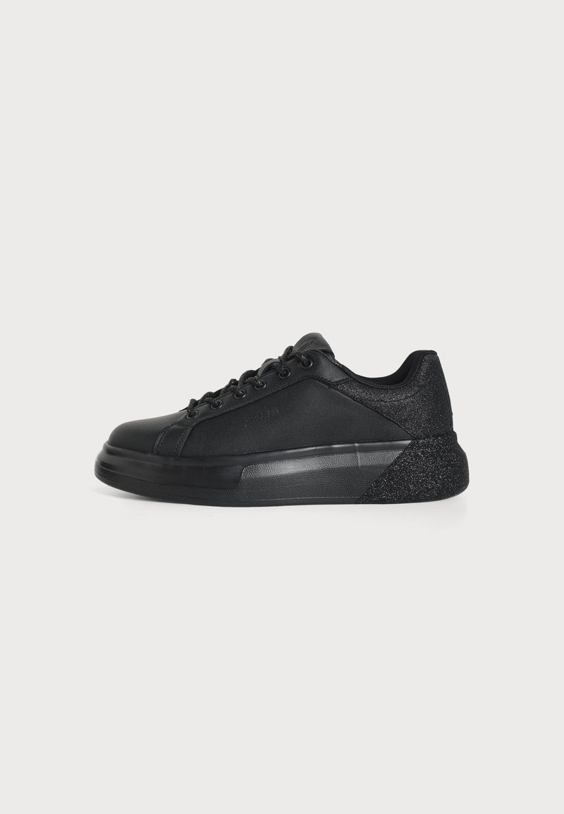 Μαύρο χαμηλό sneaker με κορδόνια μπροστά, λείο και υφή υλικών, και χοντρή σόλα, εμφανιζόμενο σε πλάγια όψη σε λευκό φόντο.