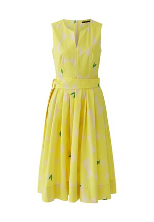 Robe midi jaune sans manches avec ceinture large, motif à carreaux subtil et petits détails de feuilles vertes, corsage ajusté, jupe plissée évasée.