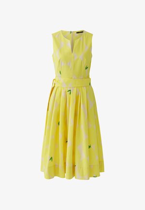 Ärmelloses gelbes Midikleid mit breitem Gürtel, dezentem Karomuster und kleinen grünen Blättern, tailliertem Oberteil und ausgestelltem plisziertem Rock.