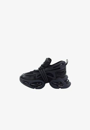 Czarny futurystyczny sneaker z grubą, segmentowaną podeszwą, cholewką z siateczki i skóry, wyściełanym językiem oraz pętelką do zakładania na pięcie.