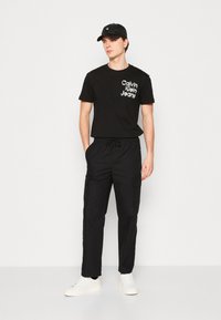 Calvin Klein Jeans STACKED EUPHORIC LOGO TEE - Camiseta estampada - black