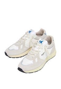 Zapatillas beige que combinan materiales de ante y malla, con acentos en blanco, puntera redonda y ligera amortiguación, además de una suela de goma texturizada.