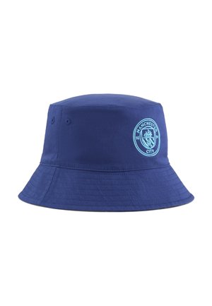 Námornícky modrý kyblíkový klobúk vyrobený z odolnej látky, s pevnou korunou, širokým okrajom a vyšitým logom Manchester City na prednej strane.