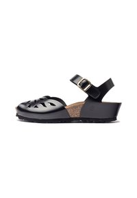 Sandale en cuir noir avec un design à découpes, semelle en liège, sangle ajustable avec boucle dorée et semelle noire texturée.