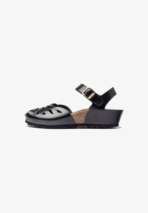 Sandale en cuir noir avec un design à découpes, semelle en liège, sangle ajustable avec boucle dorée et semelle noire texturée.