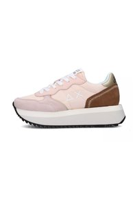 Sneaker rosa chiaro realizzato in materiali scamosciati e in pelle, con lacci bianchi e un accento in suede marrone. Suola bianca spessa con una parte inferiore nera e strutturata.