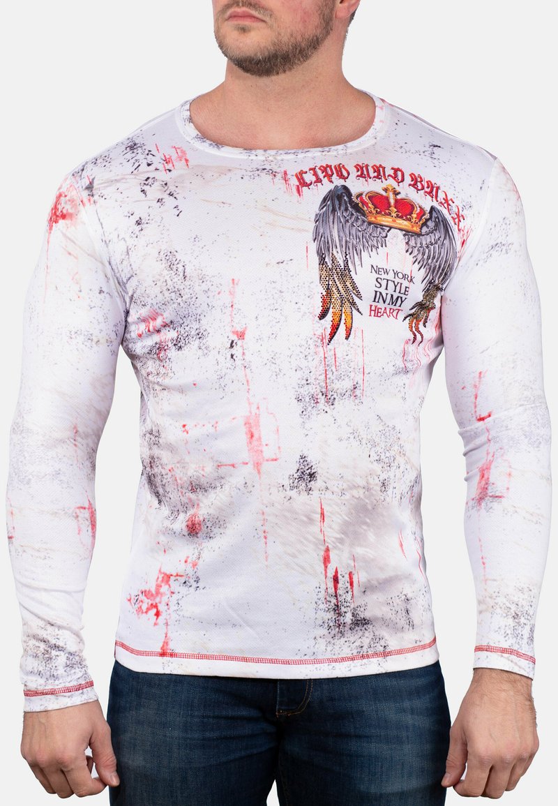 Langarmshirt in Weiß mit roten und schwarzen Spritzmustern. Verfügt über ein grafisches Adlerdesign mit Krone und Text sowie strukturiertem Stoff.