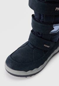 Mørkeblå vinterstøvler laget av semsket skinn og nylon, med tre justerbare borrelåsstropper og en teksturert gummisåle.