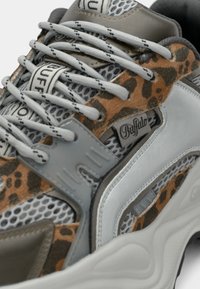 Χοντρά αθλητικά παπούτσια με γκρι και λεοπάρ εμπριμέ πάνω μέρος, με πάνελ από δίχτυ, γκρι κορδόνια και λογότυπα της μάρκας. Υφή στη σόλα από καουτσούκ.