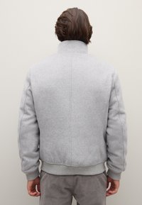Grijze bomberjack van een wollen mix met een hoge kraag, geribbelde manchetten en zoom, voorzien van subtiele stiksel-details en een relaxte pasvorm.