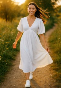 Witte midi-jurk met pofmouwen, textuurstof, diepe V-hals, vloeiende rok; gecombineerd met witte sneakers; natuurlijke buitenomgeving.