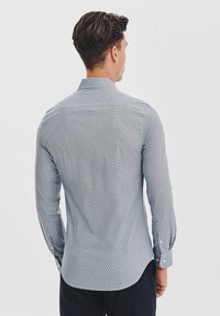 Koszula slim fit z tkaniny bawełnianej, w jasnoniebieski i biały geometryczny wzór, z długimi rękawami i wyprofilowanym kołnierzykiem. Gładka textura.