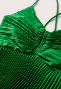 Robe plissée verte avec des plis horizontaux, une texture satinée lisse, des bretelles fines ajustables et des détails froncés au niveau du buste.