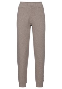 Grijze sweatpants van zacht materiaal. Heeft een hoge tailleband en taps toelopende benen. Opvallend detail: witte bedrukte tekst op het linker onderbeen.