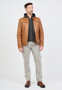 Brun læderjakke med lynlåslommer, parret med en grå hoodie, lys grå jeans og brune støvler. Enkel, strømlinet design.