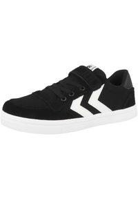 Schwarze Wildledersneaker mit einer weißen Gummisohle, die weiße Zickzackakzente, ein Schnürdesign und einen Klettverschluss für zusätzlichen Halt aufweisen.