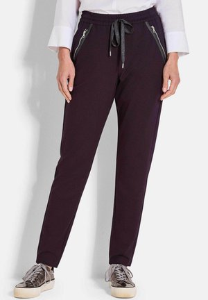 Paarse joggingsbroek met elastische tailleband en trekkoord, voorzien van twee zijzakken met rits met zilverkleurige details en een gladde textuur.