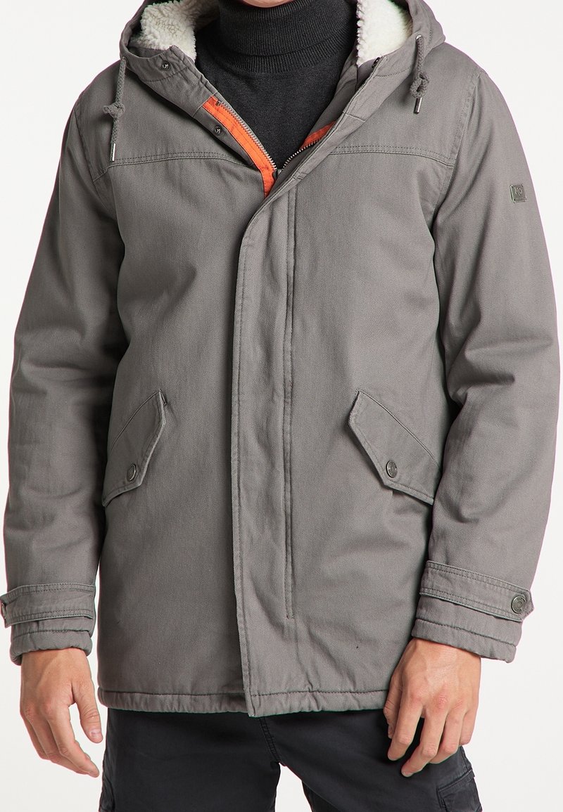 Veste à capuche grise avec fermeture éclair à l'avant, accents orange et doublure intérieure douce et chaude. Comprend des poches latérales et des poignets ajustables.