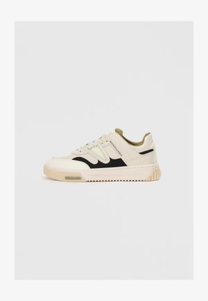 Sneaker low beige con accenti neri, dettagli perforati, collo imbottito e marchio "Scotch & Soda" sul pannello laterale.