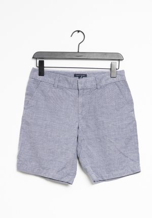 Lysegrå casual shorts med bæltestropper og sidelommer hængende på en sort plastikbøjle mod hvid baggrund.