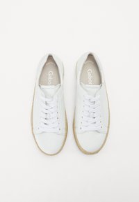Sneakers bianchi in pelle con punta rotonda e lacci bianchi. Suola con texture naturale. Marchio "Gabor" all'interno. Design semplice e classico.